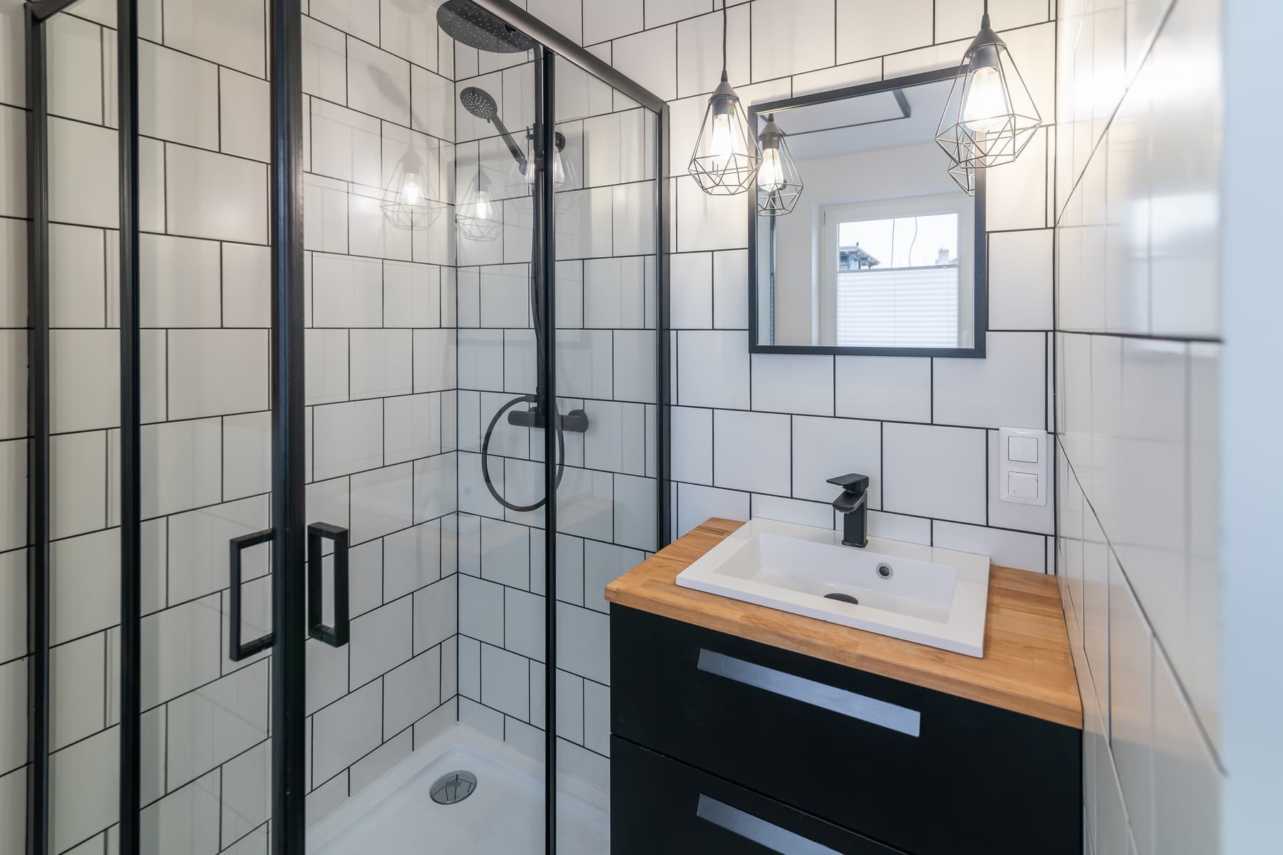 Walk-in shower with black frame glass and white tile