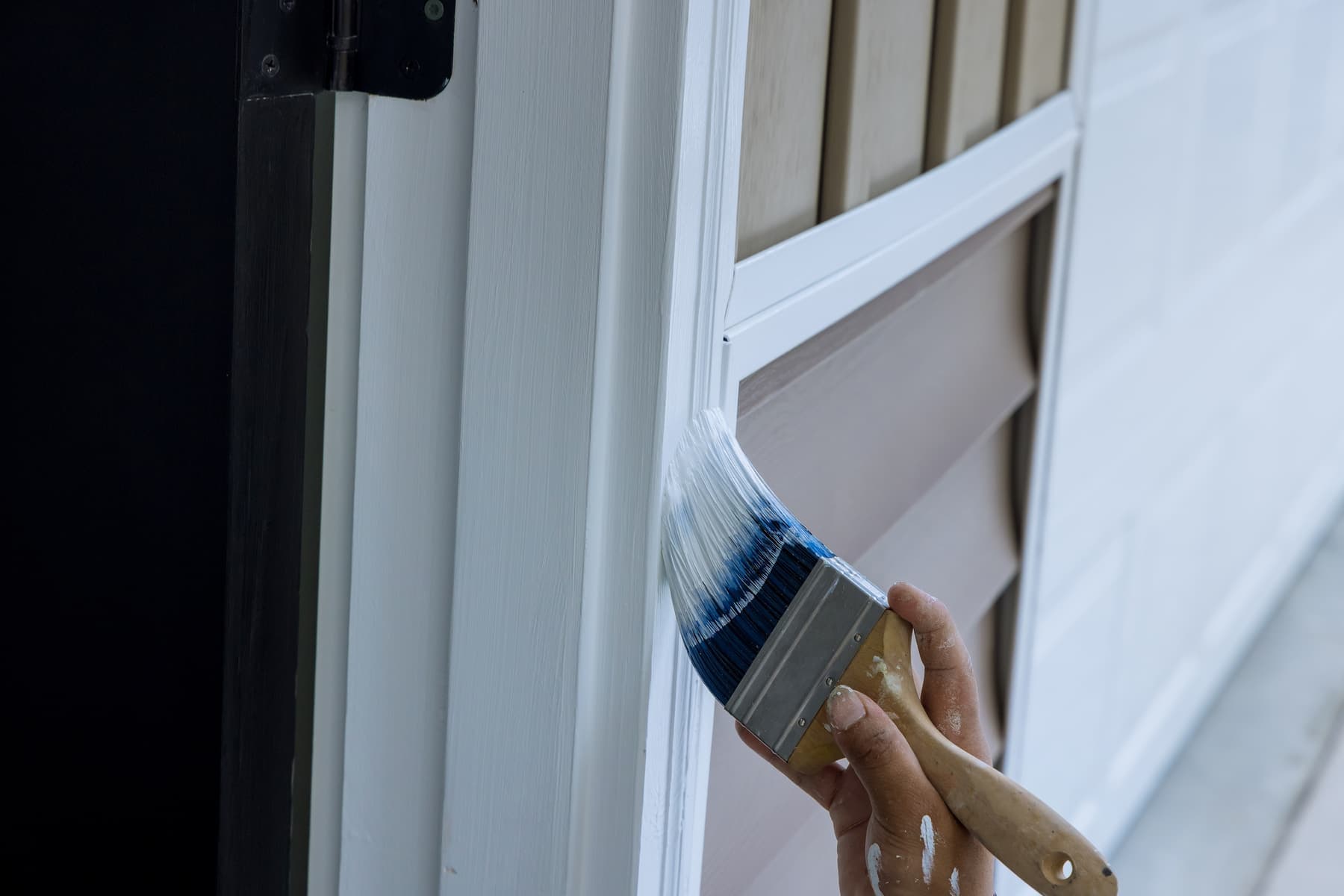 Brush cutting in paint along exterior trim