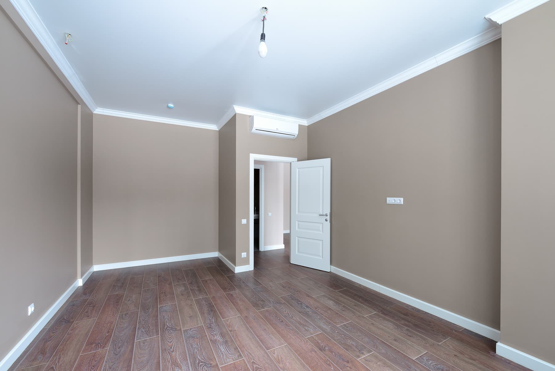 Empty room with new paint, white trim and wood floors